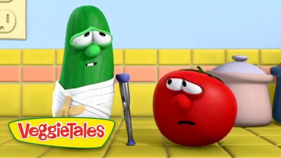 Green cucumber with a white bandage and crutch speaks to a worried red tomato in a bright yellow kitchen, VeggieTales scene.