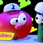 Red tomato and green cucumber wearing blue and white caps, looking at each other with puzzled expressions; VeggieTales logo in the bottom-left corner.
