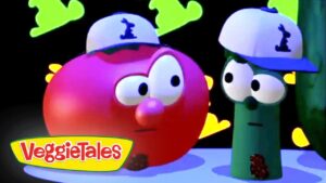 Red tomato and green cucumber wearing blue and white caps, looking at each other with puzzled expressions; VeggieTales logo in the bottom-left corner.