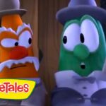 Two VeggieTales characters in formal attire—orange one with a top hat and white mustache and a green cucumber-like character in a bow tie—stand side by side, looking surprised, with a VeggieTales logo in the corner.