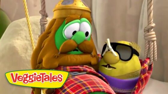 Two VeggieTales characters—a green cucumber with a Viking-style helmet and mustache, and a yellow pepper wearing sunglasses and a purple scarf—tied to ropes on a set, VeggieTales logo visible.