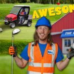 Cheerful worker in hard hat and orange vest holding a golf club and ball in front of a red building labeled 'THE GOLF BARN' with a cart and golf balls in the background, text 'AWESOME!'