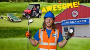 Cheerful worker in hard hat and orange vest holding a golf club and ball in front of a red building labeled 'THE GOLF BARN' with a cart and golf balls in the background, text 'AWESOME!'