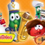 Colorful VeggieTales band of anthropomorphic vegetables playing instruments—drums, a brass instrument, keyboards, and guitar—against an orange polka-dot background, with the VeggieTales logo in the bottom-left.