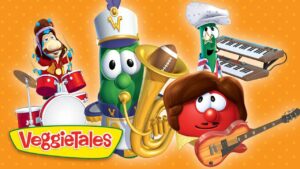 Colorful VeggieTales band of anthropomorphic vegetables playing instruments—drums, a brass instrument, keyboards, and guitar—against an orange polka-dot background, with the VeggieTales logo in the bottom-left.