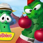 Two VeggieTales vegetables wearing boxing gloves in a sunny desert arena, with the VeggieTales logo in a yellow banner at the bottom left.