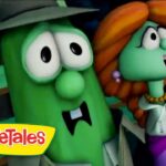 Two VeggieTales characters, a green cucumber with a hat and a green-haired figure with orange hair, sharing a moment on screen.