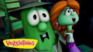 Two VeggieTales characters, a green cucumber with a hat and a green-haired figure with orange hair, sharing a moment on screen.