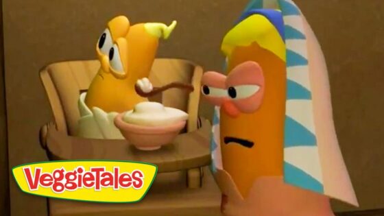 Animated VeggieTales scene: two cartoon vegetables at a table, one offering a bowl of dessert to the other, with a colorful towel-wrapped figure nearby.
