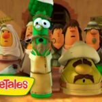 CGI VeggieTales characters gathered in a doorway, with a green mustached figure at the center wearing white robes.