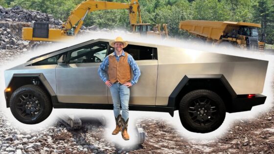 Man in cowboy hat and vest standing beside a silver Cybertruck on a rocky construction site.