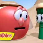Red tomato and green cucumber VeggieTales characters wearing desert head coverings, talking in a sandy canyon with the VeggieTales logo in the lower-left corner.
