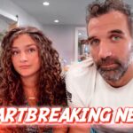 Two adults sit indoors, facing the camera; a bold red 'HEARTBREAKING NEWS' banner spans the bottom of the image.