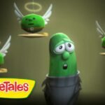 Animated green cucumber character stands center, looking worried as three winged green peas with halos float around him, VeggieTales logo in the bottom left corner.