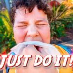 Person with eyes squeezed shut, biting a tissue in their mouth outdoors, with bold 'JUST DO IT!' text across the bottom.