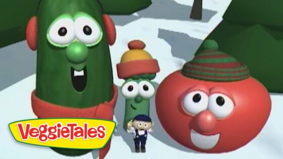 Three VeggieTales characters—a tall cucumber, a small green bean, and a red tomato with hats—pose in a snowy scene with a tiny man in front and the VeggieTales logo.