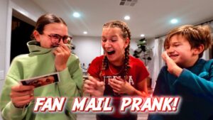 Thumbnail of three kids indoors laughing during a fan mail prank; left kid in green hoodie holds a card, center girl with braids laughs, right boy smiles; bold 'FAN MAIL PRANK!' caption at bottom.