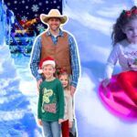 Smiling man in a cowboy hat and vest poses with two children at a snowy indoor slide, while others sled nearby under snowflakes.