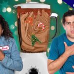 Two people look shocked beside a blender filled with chocolate swirl and holiday decorations (gingerbread, candy cane, Christmas tree) against a festive green background with an 'exclusive' banner.