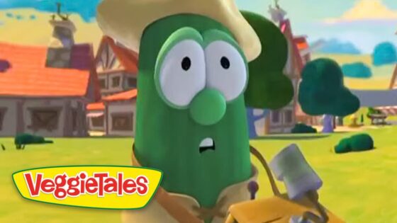 Green cucumber VeggieTales character wearing a straw hat, looking surprised in a sunny cartoon village setting.