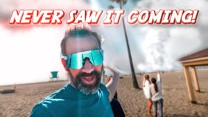 Humorous meme banner: man on a sunny beach wearing reflective sunglasses with the caption 'Never saw it coming!' across the top.