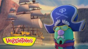 VeggieTales logo in the foreground with a green pirate character wearing a blue tricorn hat and yellow glasses, sailing beside a large pirate ship on a rocky sea.