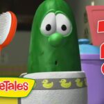VeggieTales pickle character looks surprised with a red question mark and a hairbrush nearby.