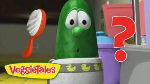 VeggieTales pickle character looks surprised with a red question mark and a hairbrush nearby.