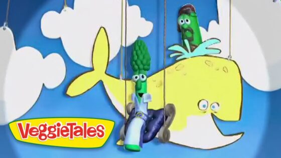 Three vegetable puppets hang on strings in front of a blue sky backdrop with a yellow whale and VeggieTales logo in the corner.