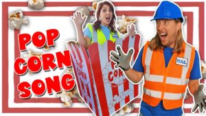 Thumbnail of a man in an orange safety vest and hard hat, a surprised woman in a safety vest, a giant popcorn box, and bold POP CORN SONG text.