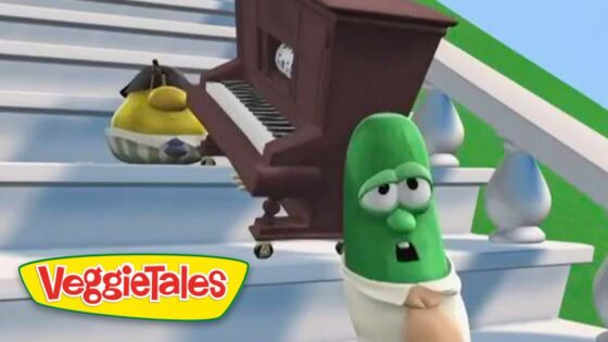 VeggieTales scene with a green vegetable character looking surprised as a brown piano is rolled up stairs, logo VeggieTales in the corner.