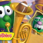Two VeggieTales characters in a desert canyon, one playing a shiny brass tuba, VeggieTales logo visible below.