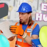 Construction worker in a blue hard hat and orange vest reads a handwritten note beside colorful Easter eggs; 'EGG HUNT' text on screen.
