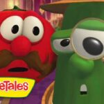 Two VeggieTales vegetables—a surprised red tomato with a brown mustache and a green cucumber—stand in a hallway, the cucumber holding a magnifying glass to its eye.