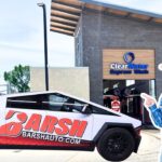 Branded BARSH Auto vehicle in front of ClearWater Express Wash, with a life-sized cowboy cutout pointing at the car.
