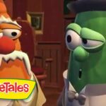 Two VeggieTales characters, an orange carrot and a green cucumber, in a wood-paneled room wearing formal clothes and talking together.