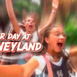 Thumbnail of two excited riders on a Disneyland ride, arms raised, with bold red and white text reading 'OUR DAY AT DISNEYLAND' overlaid in the foreground.