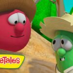 Two VeggieTales characters, a red round veggie with a straw hat and a green cucumber with a large hat, smile at each other in a sunny outdoor scene.