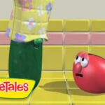 From VeggieTales: a green vegetable in a yellow floral shirt looms over a red, worried tomato on a yellow tiled floor.