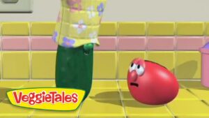 From VeggieTales: a green vegetable in a yellow floral shirt looms over a red, worried tomato on a yellow tiled floor.