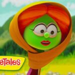 Green VeggieTales character with an orange hood in a sunny meadow, logo visible in the corner