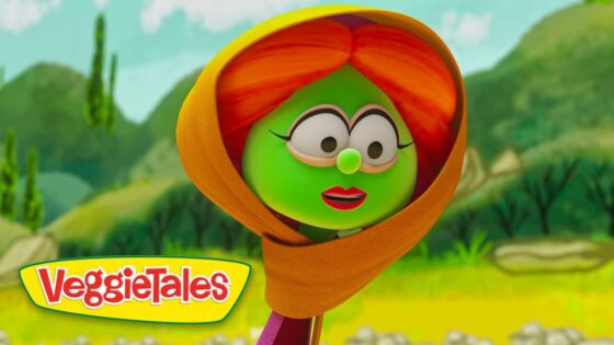 Green VeggieTales character with an orange hood in a sunny meadow, logo visible in the corner