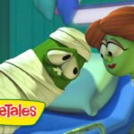 VeggieTales scene: a green mummy-like character wrapped in bandages on a hospital bed, leaning toward a woman with red braided hair.