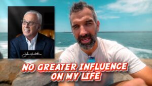 Thumbnail of a man at the beach with bold red-and-white text: 'NO GREATER INFLUENCE ON MY LIFE'; inset portrait of an older man in a suit on the left side.