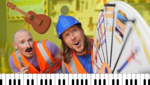 Two construction workers in orange safety vests lean toward a large prize wheel, a cartoon guitar sticker floating overhead, and a piano keyboard at the bottom edge for a playful scene.