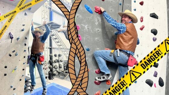 Two climbers in cowboy outfits scale an indoor rock wall; yellow DANGER tape frames the scene.