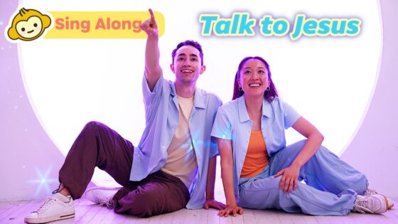 Two smiling hosts sit on the floor in pastel outfits, inviting viewers to sing along and talk to Jesus.