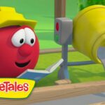 Red VeggieTales tomato wearing a yellow hard hat reads a book beside a cement mixer on a construction site.