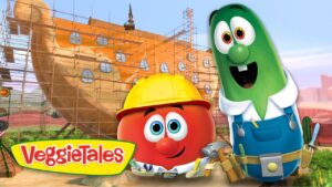 Tomato and cucumber VeggieTales characters in hard hats stand beside a ship under construction with scaffolding, logo visible on the bottom left.