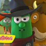 Green vegetable character wearing a black hat, with a bronze-brown animal beside him, in a VeggieTales scene with a yellow VeggieTales logo bottom left.